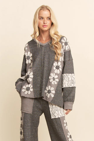 Woman wearing a gray and white floral patterned outfit on a beige background