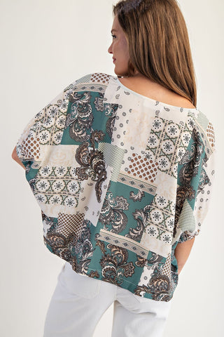 Woman wearing a patterned blouse with a plain background
