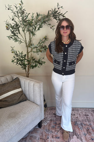 Woman standing in a living room with a plant and sofa
