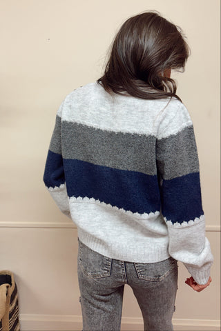 Person wearing a striped sweater with a neutral background
