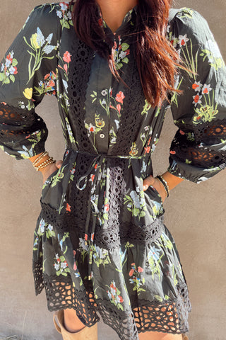 Black floral dress with sheer overlay on a plain background