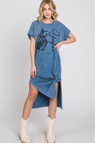 Woman wearing a blue denim dress with a graphic design on a gray background