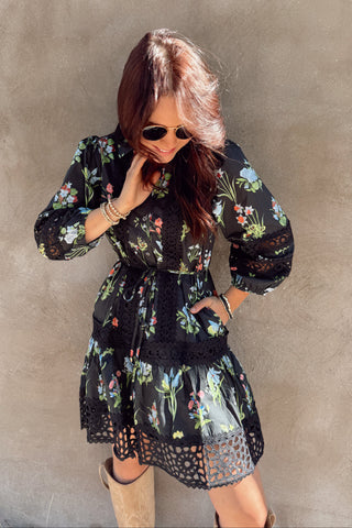 Woman wearing a floral dress against a gray wall