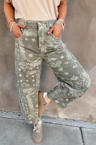 Person wearing green patterned pants against a plain background