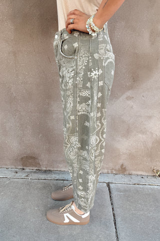 Person wearing light-colored pants with a subtle pattern on a concrete floor.