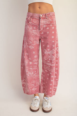 Pink bandana-patterned jeans worn by a person on a white background