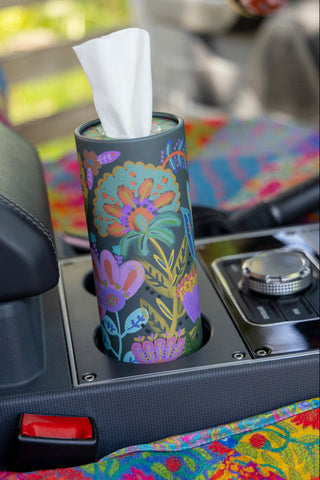 Floral-patterned tissue holder on a car dashboard with colorful interior.