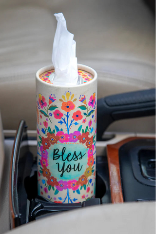 Tissue holder with floral design and 'Bless You' text in a car.