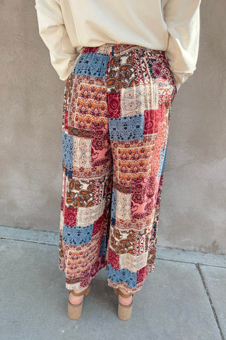 Person wearing a patterned pants with a neutral background