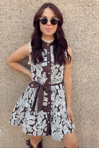 Woman wearing a floral dress with a beige wall background