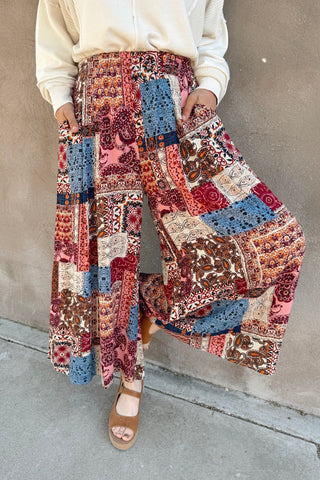 Person wearing a colorful patchwork skirt against a neutral background