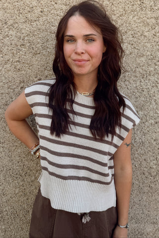 Woman wearing a striped shirt against a textured wall