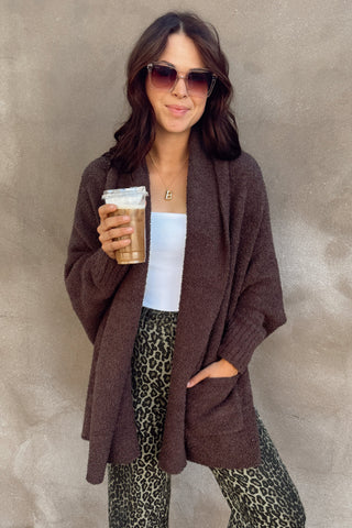 Woman holding a coffee cup against a textured wall