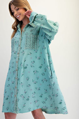Woman wearing a light blue floral dress against a white background